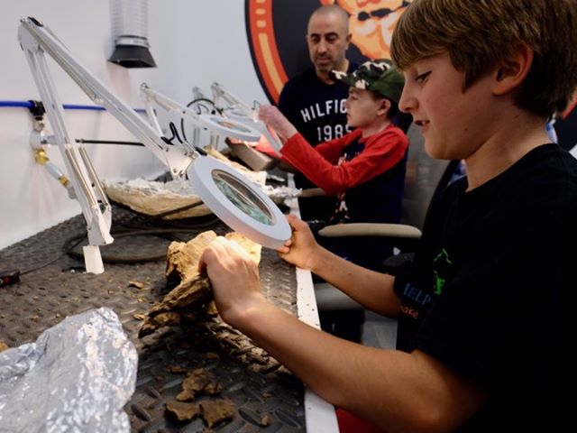 Fossil Prep in Action  Some of our junior VIP guests from the Help Fill A Dream Foundation working on triceratops bones.