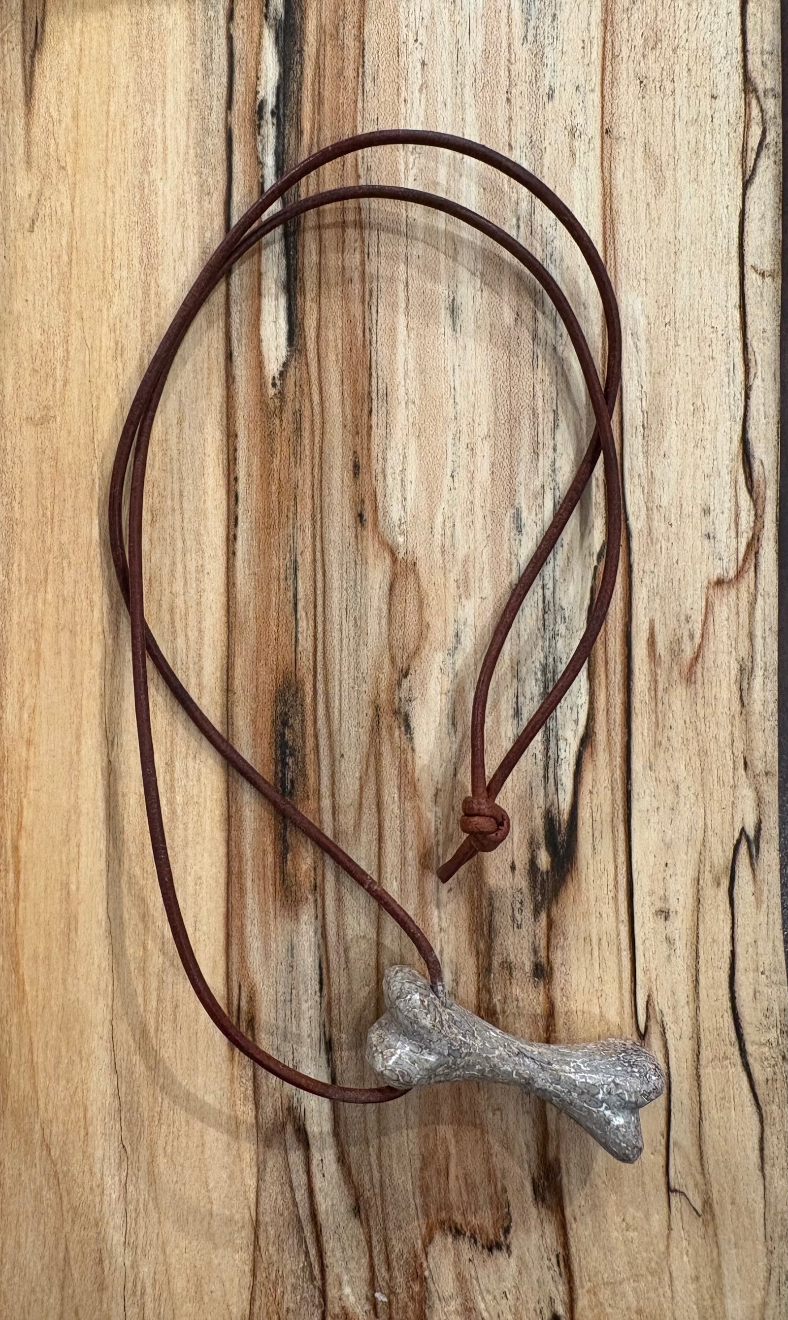 Corded dinosaur bone pendant